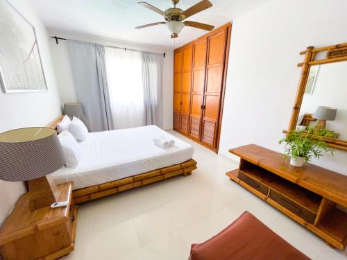 a bedroom with a bed and a table and a mirror at LOS CORALES Resort VILLAS & Apartments WIFI BEACH Club & SPA in Punta Cana