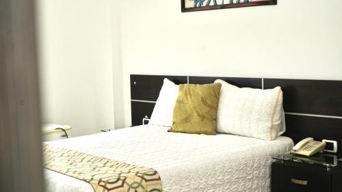 a bedroom with a bed with a phone on it at Gran Hotel Internacional Sanbara in Arauca