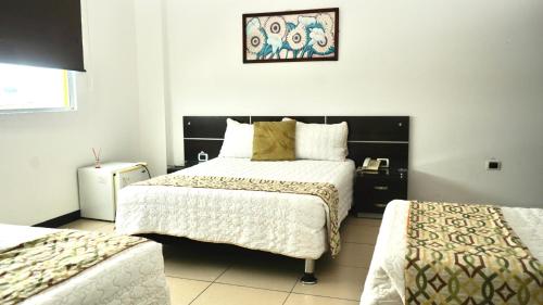 a bedroom with two beds and a picture on the wall at Gran Hotel Internacional Sanbara in Arauca