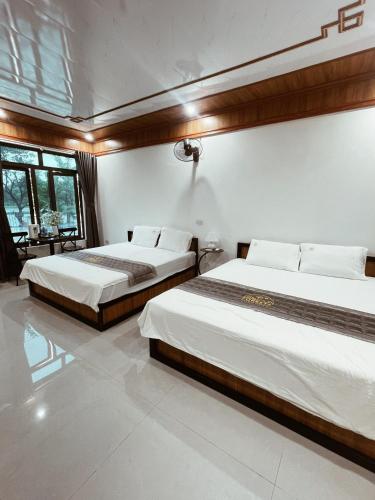 a bedroom with two beds and a table at Foresta Ninh Binh Homestay in Ninh Binh