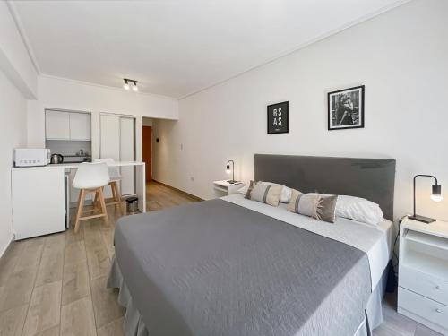 Un dormitorio con una cama grande y una cocina. en Ayres Suites Saenz Peña, en Buenos Aires
