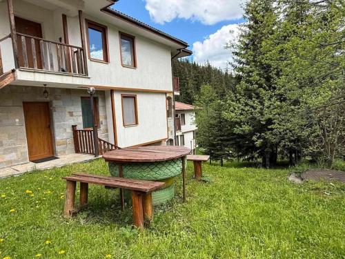 a picnic table and benches in front of a house at Pamporovo Duplex Apartment Fireplace 2 Bathrooms Shuttle in Smolyan