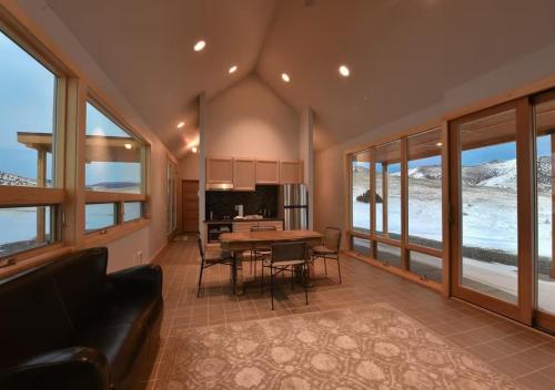 a living room with a table and chairs and windows at Erik's Ranch in Livingston
