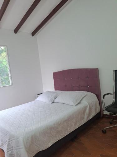 a bedroom with a large bed and a chair at Piedra Alcala in Ibagué