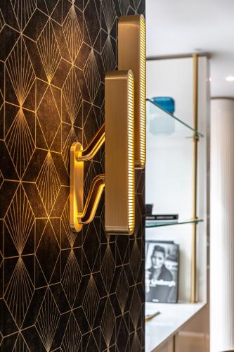 a kitchen with a wall with a gold sign on it at Hôtel Nude Paris - Color Vision in Paris