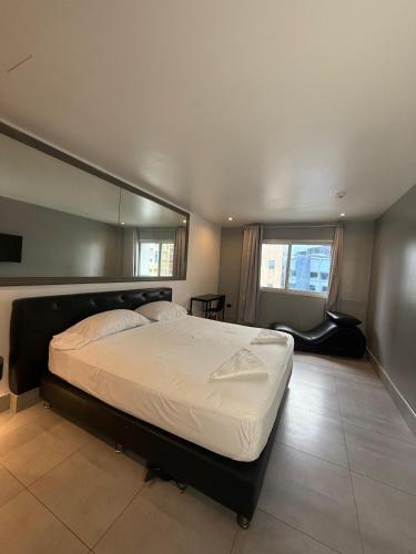 a bedroom with a large bed and a mirror at Residencial & Hotel Palazzo in Panama City