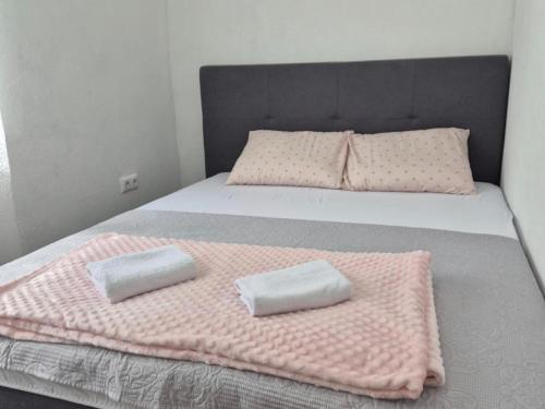 a bed with pink blankets and pillows on it at Jelena in Jajce