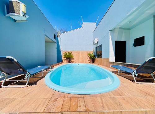 a hot tub on a patio with two chairs at Casa 19 pessoas, piscina e jacuzzi in Nova Mutum