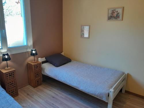 a small bedroom with a bed and two lamps at Le gîte de l'Ecureuil - 4 personnes in Donges