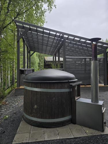 a large wooden tub sitting under a pergola at The Haven of Riverside - Villa Sieripirtti in Rovaniemi