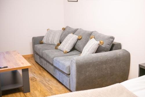 a gray couch in a living room with a table at Go-Gudauri The Atrium Residence in Gudauri