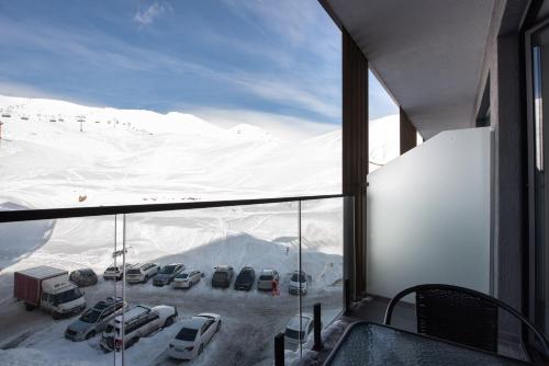 a view of a parking lot with cars in the snow at Go-Gudauri The Atrium Residence in Gudauri