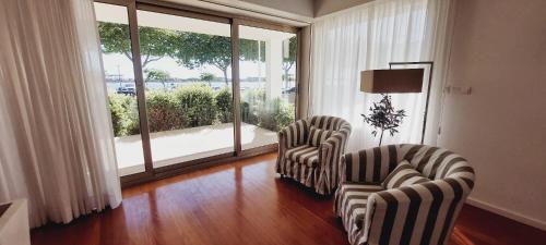 a living room with two chairs and a large window at La Maison Piaf in Esposende