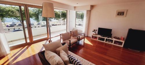 a living room with a couch and a flat screen tv at La Maison Piaf in Esposende
