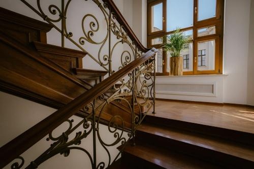 a staircase with a wrought iron railing and a window at IBB Hotel Grand Hotel Lublin in Lublin