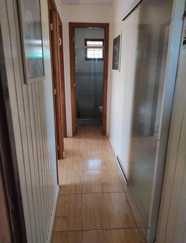 a hallway with a glass door leading to a bathroom at Pousada Albino Goedert in Passo De Torres