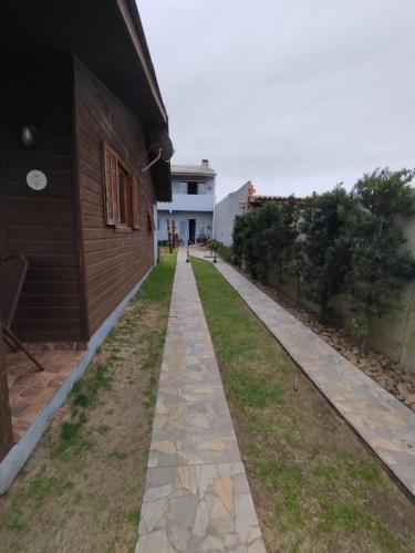 a walkway next to a building next to a house at Pousada Albino Goedert in Passo De Torres