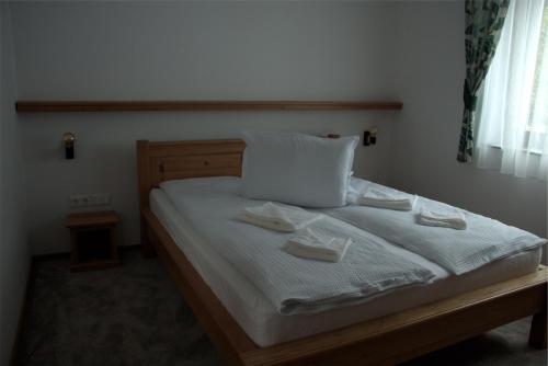 a bedroom with a bed with two towels on it at Király Apartments in Praid