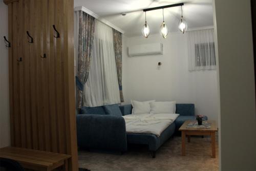 a living room with a blue couch and a bed at Király Apartments in Praid