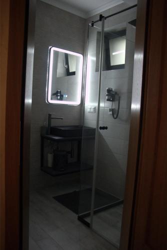a bathroom with a glass shower and a sink at Király Apartments in Praid