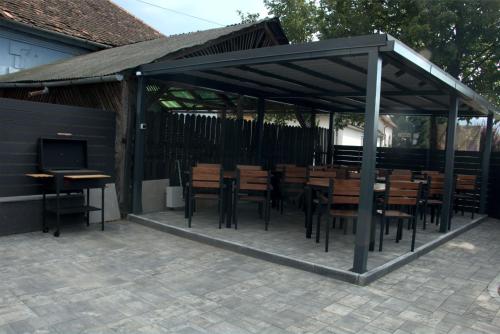 a pavilion with wooden tables and chairs and a television at Király Apartments in Praid