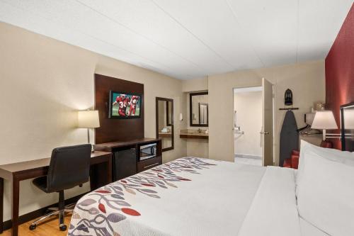 a hotel room with a bed and a desk and a computer at Red Roof Inn Lansing East - MSU in Lansing