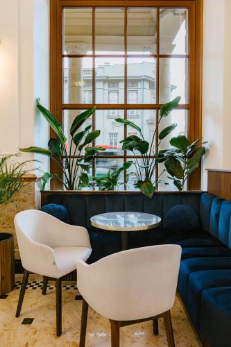 a living room with a couch and a table and chairs at IBB Hotel Grand Hotel Lublin in Lublin