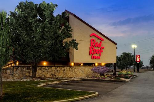 a restaurant with a red sign on the side of a building at Red Roof Inn Lansing East - MSU in Lansing