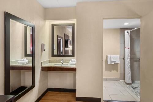 a bathroom with two sinks and a mirror at Red Roof Inn Lansing East - MSU in Lansing