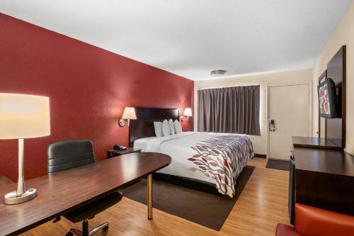 a hotel room with a bed and a desk at Red Roof Inn Lansing East - MSU in Lansing