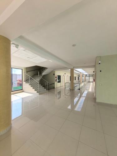 an empty hallway in a building with white tile floors at hotel hao han in Ciudad Hidalgo