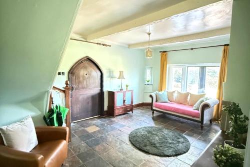 a living room with a couch and a table at 4 Bed Retreat-Sleeps 7-Parking-Garden-Lake Views in Bolton