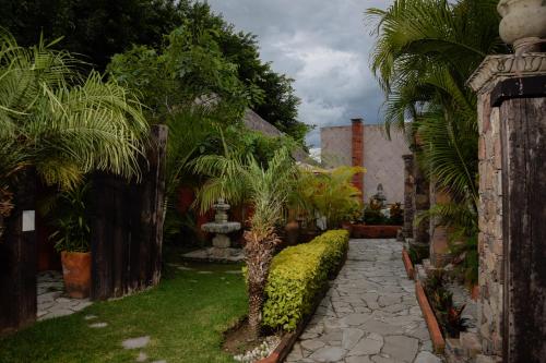 a garden with a fountain and palm trees at Casa Miura Hotel Boutique in Ajijic