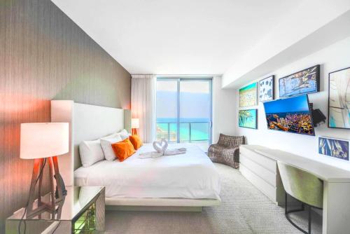 ハリウッドにあるSpectacular Sunset Views Over the Ocean at Hollywoodのベッドと机と机があるホテルの部屋