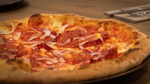 a pizza sitting on top of a plate on a table at Holiday Inn Express & Suites Lisbon - Príncipe Real by IHG in Lisbon