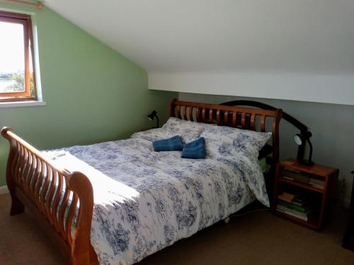 a bedroom with a bed with blue pillows on it at The Patch at Snettisham Beach in Snettisham
