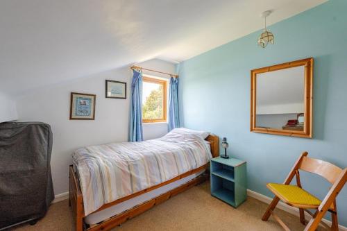 a bedroom with a bed and a mirror and a chair at The Patch at Snettisham Beach in Snettisham
