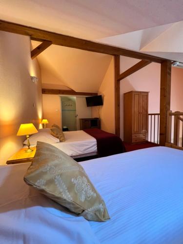 a bedroom with two beds and a pillow on a bed at Hôtel l'Orée des Roches in Saales