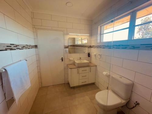 a bathroom with a toilet and a sink at Biz & Bliss Work & Serene Views in Windhoek