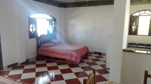 a bedroom with a bed and a checkered floor at Casa Sitio Junqueira in Mangaratiba