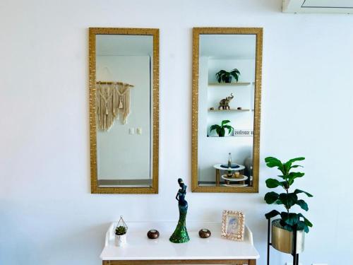 two mirrors on a white wall next to a table at Reserva Del Mar Apartamentos in Gaira