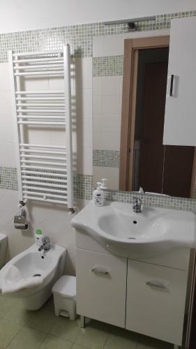a white bathroom with a sink and a toilet at Bed and Breakfast Arcobaleno - Rieti in Rieti