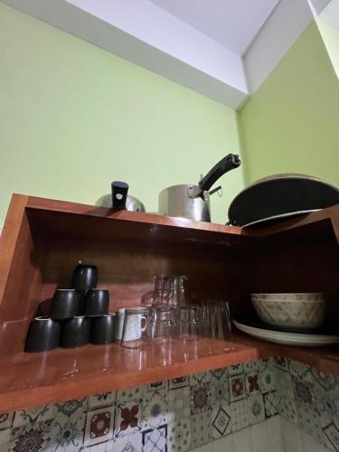 a kitchen with a shelf with pots and pans at Urban Aura 3bhk near Gs road in Guwahati