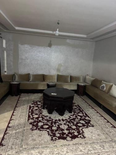 a living room with a couch and a table at Appartement 2 chambres en ferme avec Piscine Privée in Marrakech