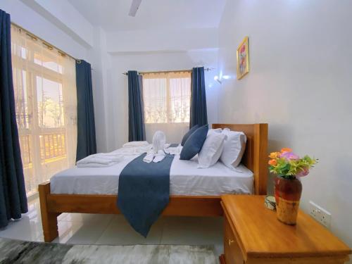 a bedroom with a large bed with blue curtains at Fairly Suites in Frere Town
