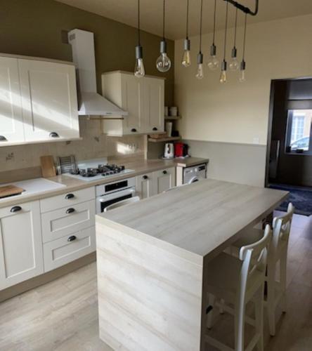 a kitchen with white cabinets and a large counter top at La Jolythalys bord de mer 300m in Étaples