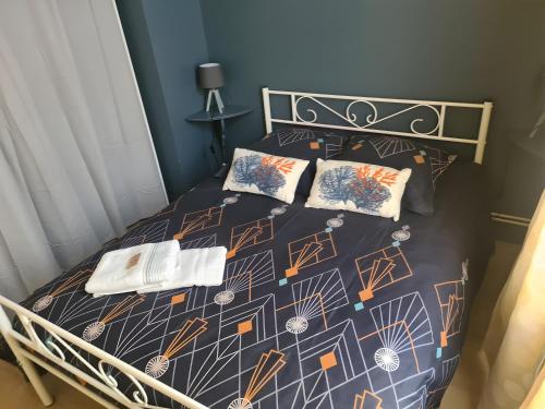 a bedroom with a bed with a comforter and pillows at La Jolythalys bord de mer 300m in Étaples