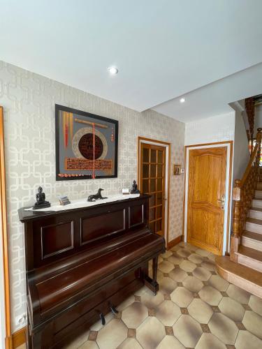 a piano in a room with a staircase at La Mansardière in Cancale