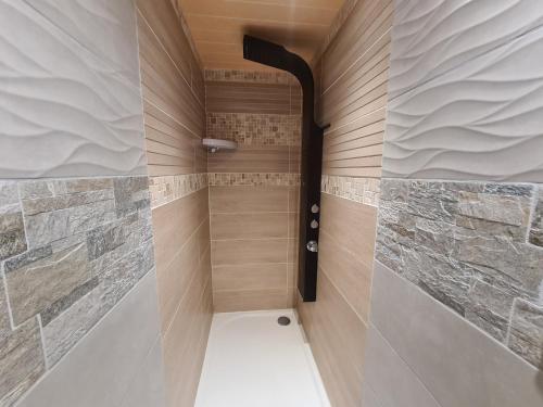 a walk in shower with a stone wall at Appartement en bord de mer in Étaples