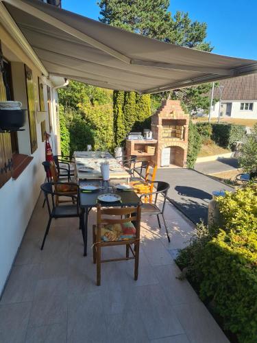 a patio with a table and chairs under a canopy at Appartement en bord de mer in Étaples